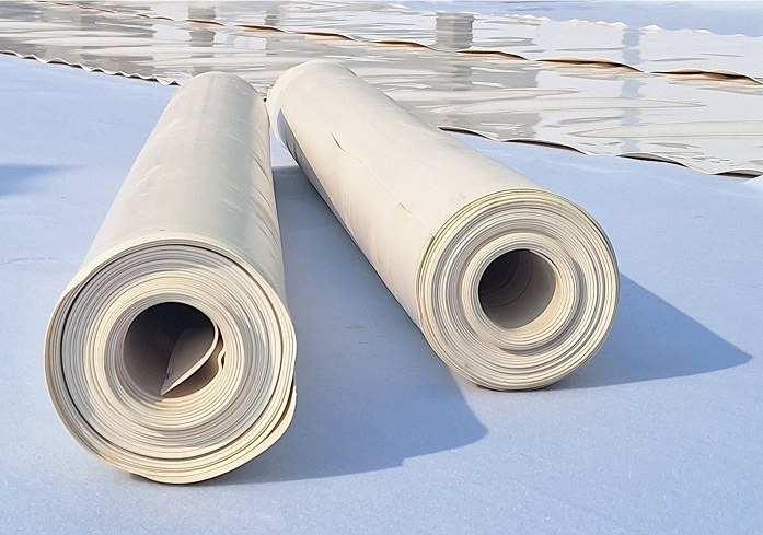 دو رول ژئوممبران PVC روی سطح آب‌بندی‌شده در حال اجرا